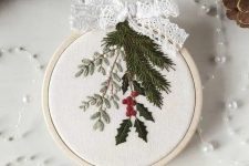 a small and lovely embroidery hoop Christmas ornament with real embroidery and a lace ribbon bow on top