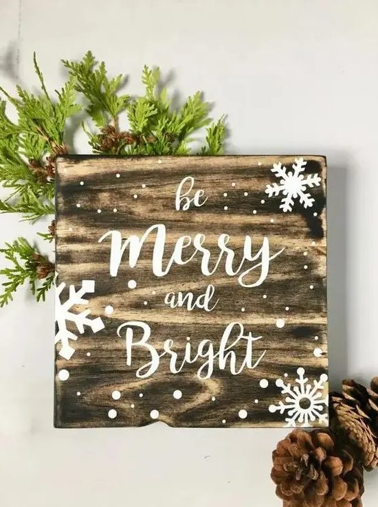 a snowy Christmas sign decorated with evergreens is an easy and very cozy holiday craft