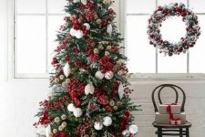 a spectacular Christmas tree with white and red ornaments, berries and lights is a very bold solution for your space