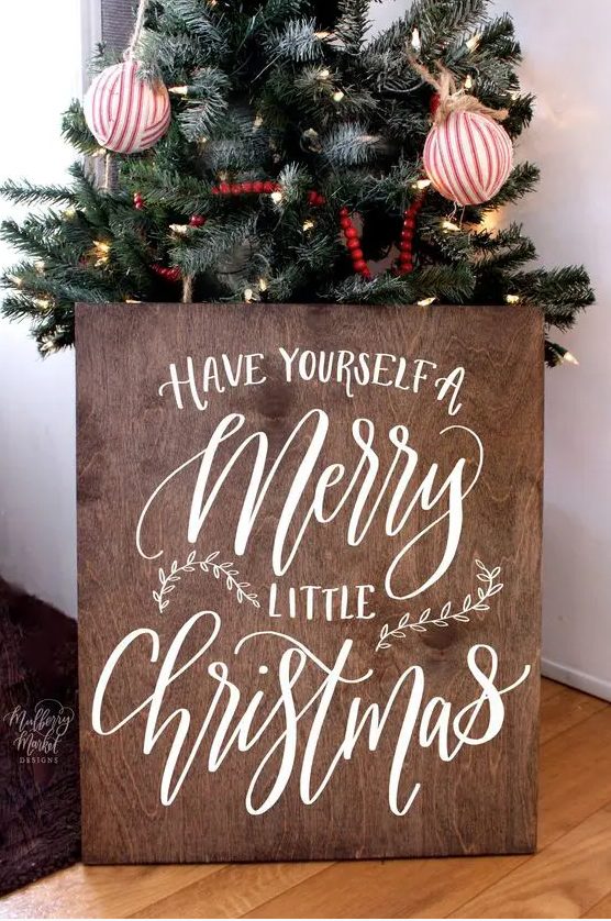 a stained plywood Christmas sign with white calligraphy will fit many decor styles and themes, especially rustic and farmhouse ones