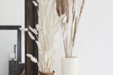 a stylish Scandinavian fall arrangement of vases, dried grasses and a white pumpkin is a cool idea for the fall