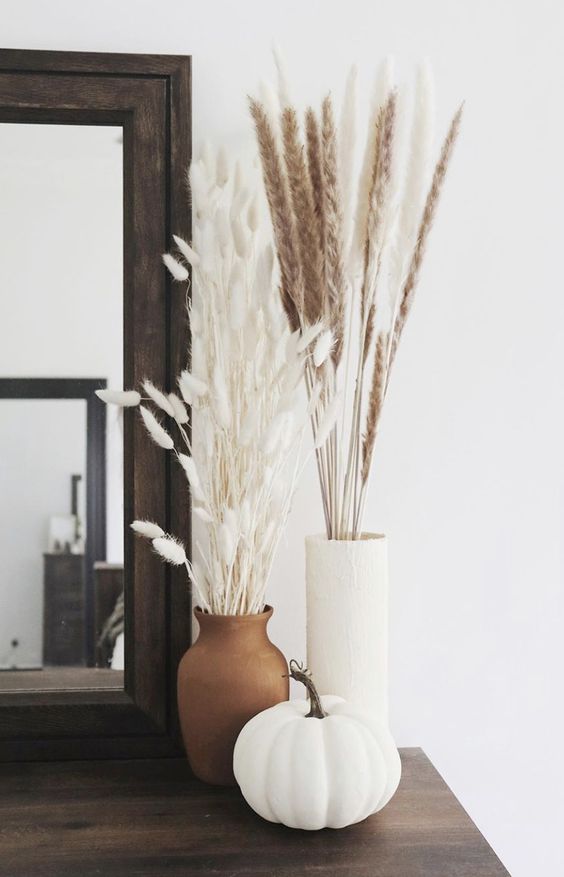 a stylish Scandinavian fall arrangement of vases, dried grasses and a white pumpkin is a cool idea for the fall