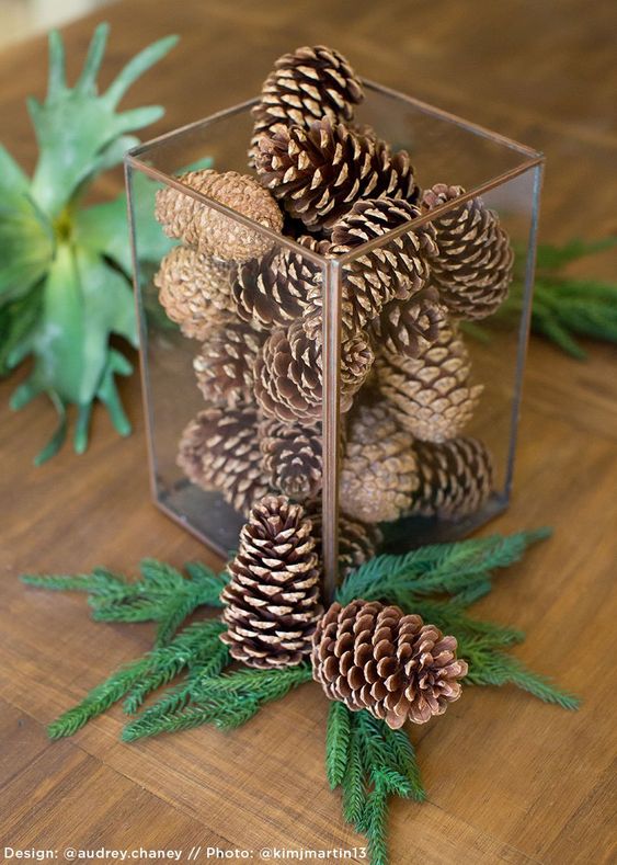 a very simple and quick Christmas centerpiece of a glass jar with pinecones, evergreens can be made in a couple of minutes