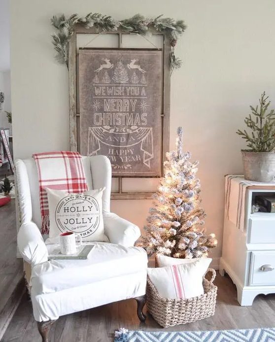 a vintage Christmas sign topped with a snowy evergreen garland is ideal for a farmhouse Christmas space