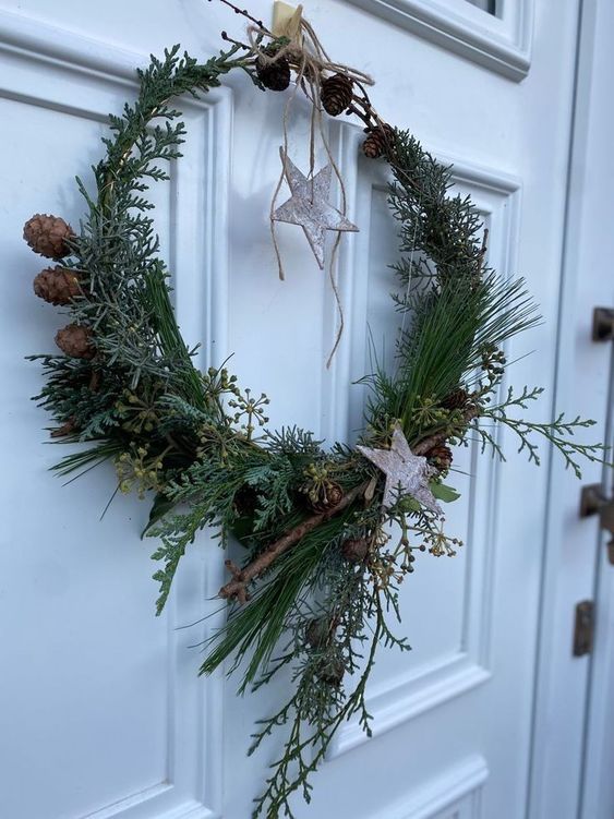 an all-natural holiday wreath covered with evergreens, branches, pinecones, branches and bark stars hanging