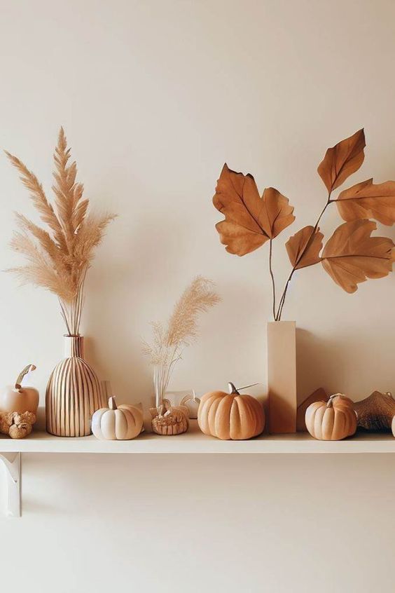 an open shelf with dried laves and grasses and some faux pumpkins is ideal for Scandi fall home decor