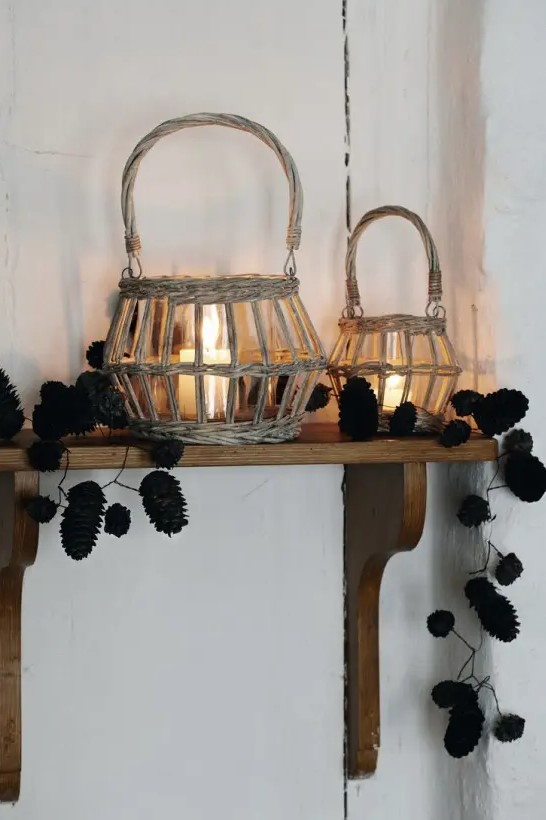 candle lanterns placed in baskets and pinecone garlands on the shelf for a natural fall feel