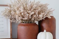 elegant and laconic Scandinavian fall decor with terracotta vases and a white pumpkin is amazing