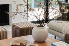 pretty and stylish Scandinavian fall decor with dried branches in a vase, a plate with beads is cool and airy