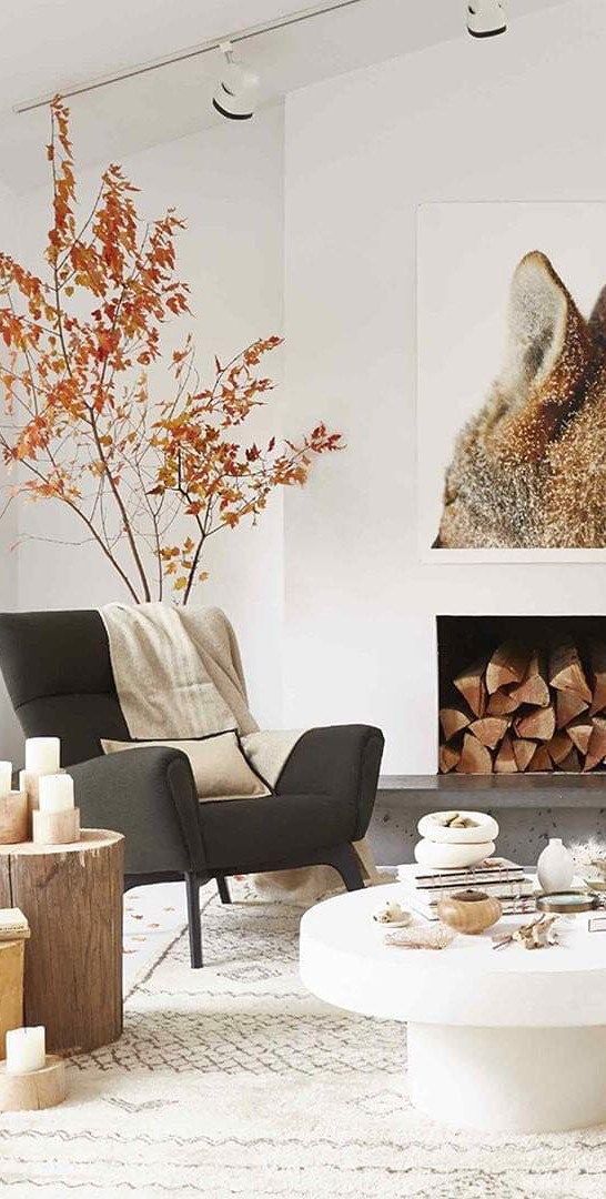 simple Scandinavian living room with tree stumps and pillar candles, some fall branches and a fox artwork