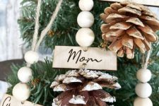 snowy pinecones with wooden beads and names can be little Christmas favors or gifts, and they will bring a natural touch to the space