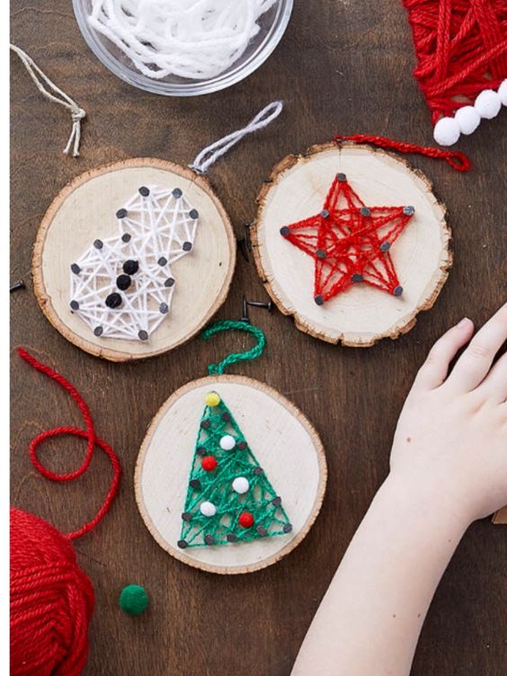 stylish Christmassy string art pieces made of tree slices and colorful yarn are amazing for woodland or rustic holiday decor