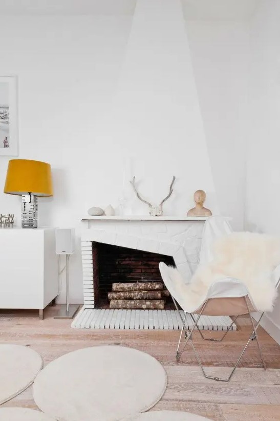 white faux fur covers and rugs, antlers, pebbles and firewood make this space Nordic yet fall like