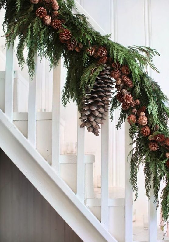 woodland banister decor for Christmas done with evergreens and small and large pinecones is a lovely idea