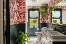 02 a bold eclectic bathroom with pink wallpaper walls, a stained vanity with two sinks, a bold and colorful rug and potted plants