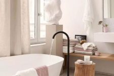 10 a lovely spa bathroom with an oval tub and a black faucet, a floating shelf, a wall-mounted sink and a sculpture on a stand