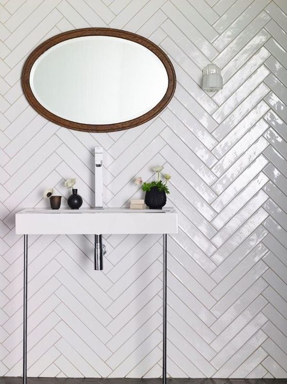long white skinny tiles clad in a chevron pattern are a stylish idea, accent the tiles with contrasting grout