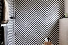 17 a bold black and white bathroom with herringbone patterned tiles and geometric ones on the floor plus black fixtures