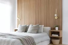 18 a contemporary neutral bedroom with a wood slat accent wall, a neutral upholstered bed with neutral bedding, floating nightstands
