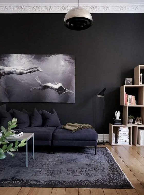 a black living room with a white ceiling, a soot sofa, a coffee table and box shelves