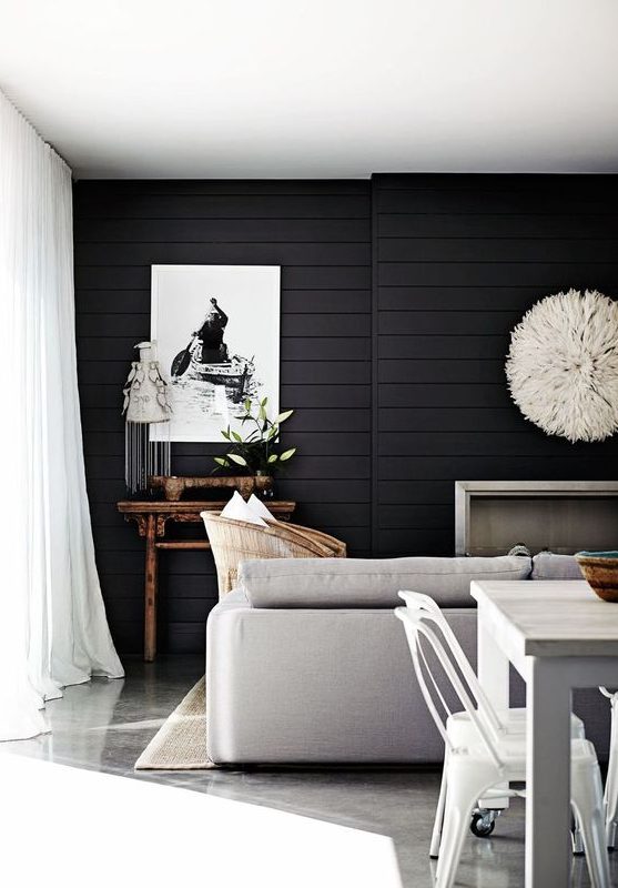 a Scandinavian living room with a black shiplap accent wall that makes a statement in this neutral space