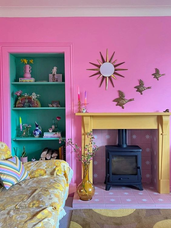 a hot pink living room with a hearth with a pink tile surround, built-in shelves, a bright printed sofa