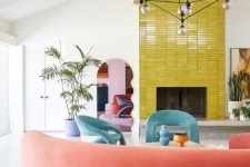46 a mid-century modern living room with a fireplace clad with yellow tile, aqua blue chairs, a curved coral sofa and potted plants