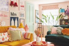 47 a living room with blush walls, a gallery wall, a dark green and yellow sofa, a coral ottoman and a pink tassel chandelier