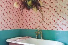 48 a bright ‘dopamine’ bathroom with bold printed wallpaper, green tile, a pink bathtub a dried grass chandelier