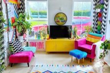 50 a bright and colorful living room with fuchsia seating furniture, bold printed textiles, potted plants and a mirror