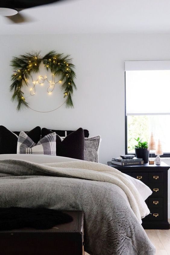 a Scandinavian Christmas wreath of evergreens and lights forming a word is a cool decor idea