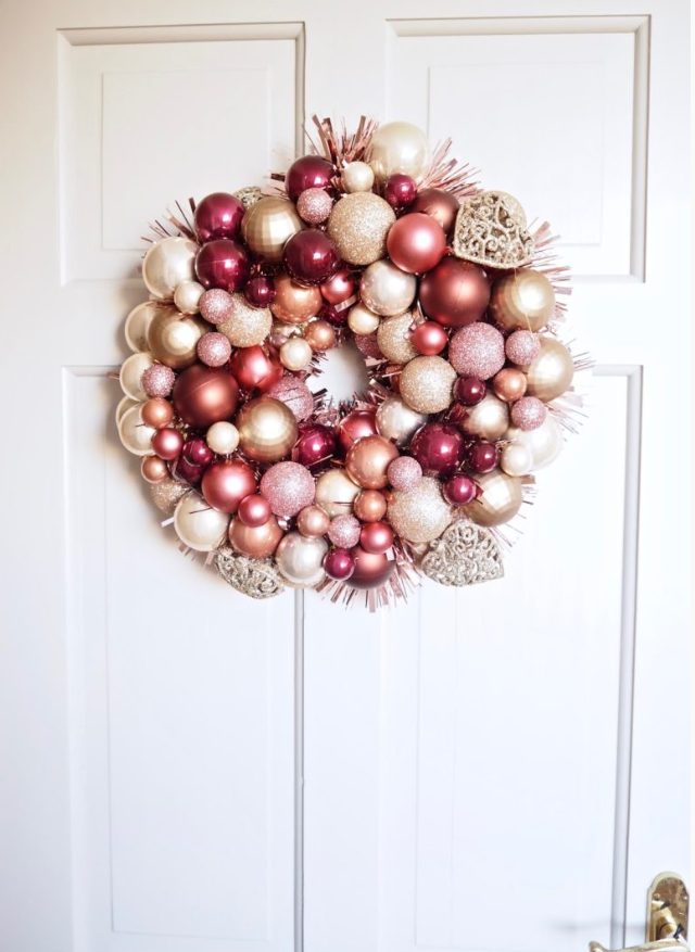 a beautiful glam Christmas wreath made of pink, blush, gold, copper ornaments and hearts is a super cool idea