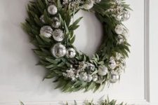 a beautiful greenery wreath with silver ornaments and beads is a lovely holiday decor idea you can steal