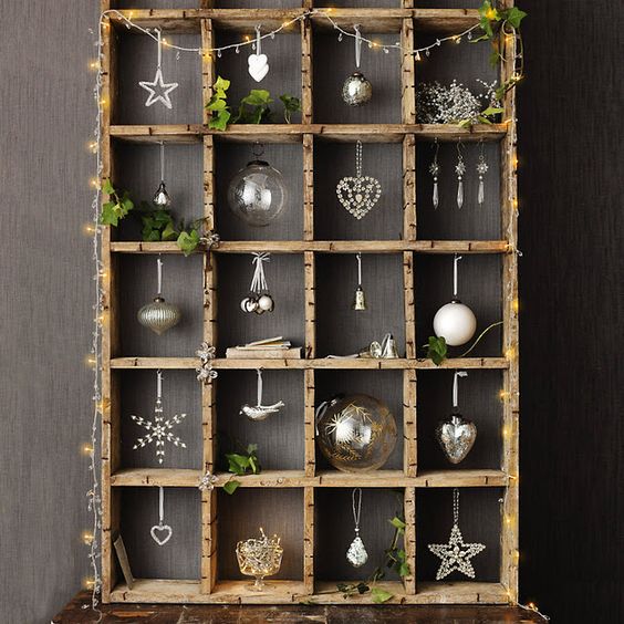 a beautiful wooden stand with various kinds of Christmas ornaments, lights and greenery is a cool solution