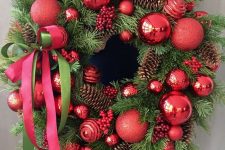 a bold and catchy Christmas wreath of evergreens, pinecones, red ornaments and a red bow is a cool and brigth decor idea