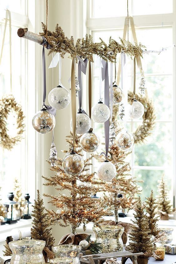 a branch with gold tinsel and white and gold ornaments is a cool Christmas ornament display