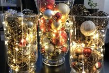a dreamy Christmas display of large and tall glasses, pinecones, vine balls, Christmas ornaments and lights