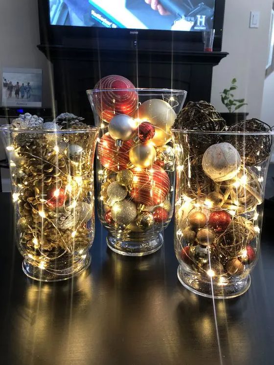 a dreamy Christmas display of large and tall glasses, pinecones, vine balls, Christmas ornaments and lights