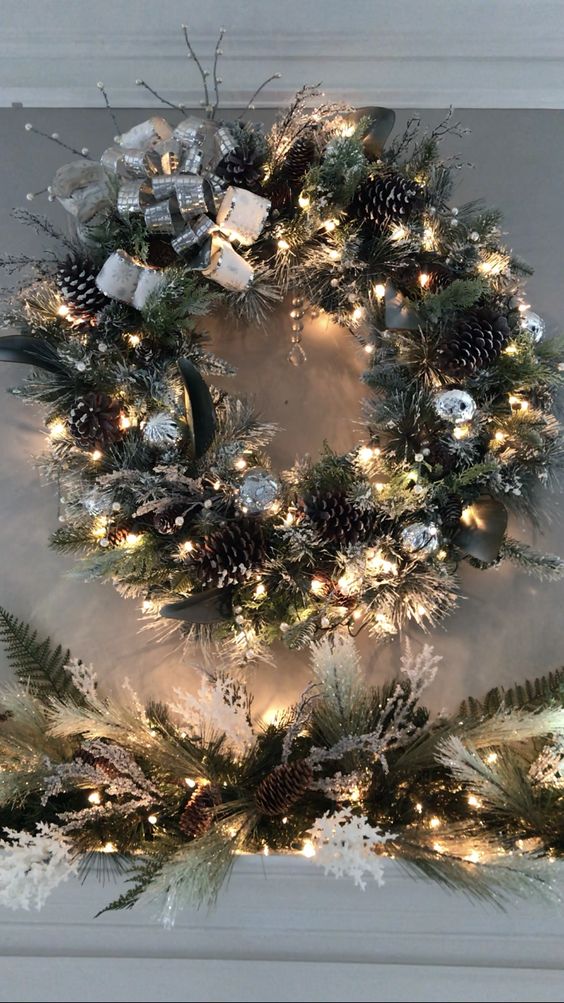 a glam Christmas wreath with evergreens, pinecones, silver leaves and bows plus lights and twigs