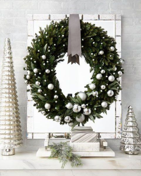 a glam holiday wreath of evegreens and leaves, silver ornaments is a chic and catchy idea for Christmas