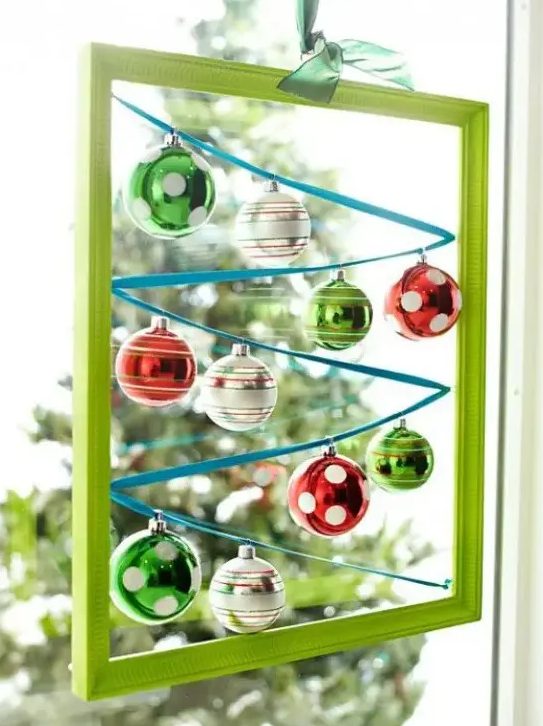 a green frame with colorful Christmas ornaments hanging inside is a cool and creative Christmas decorations
