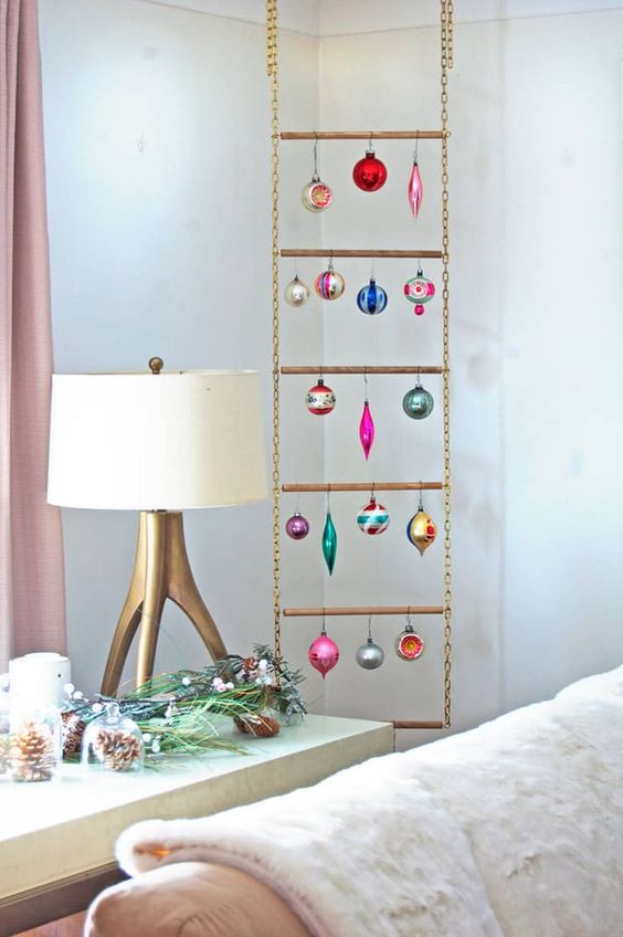a ladder made of chain and metal tubes used for displaying Christmas ornaments becomes an unusual holiday decoration