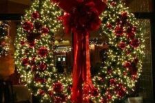 a luxurious Christmas wreath of evergreens, red ornaments and a large red bow is amazing