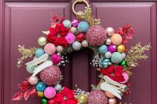 a luxurious and colorful ornament Christmas wreath with faux blooms, branches and wings is amazing