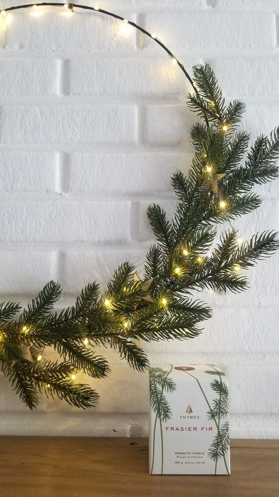 a minimal Christmas wreath with evergreens and lights is a cool idea for a minimal space