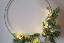 a minimal Christmas wreath with greenery and evergreens, small ornaments and a silver star is wow