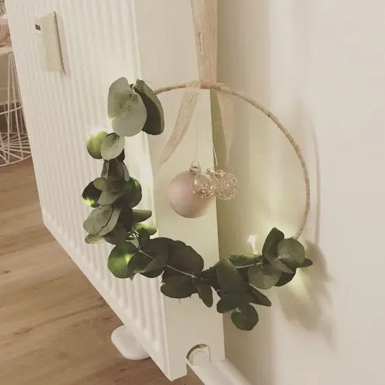 a modern Christmas wreath of an embroidery hoop, eucalyptus, mercury glass and pearl ornaments is a cool decoration