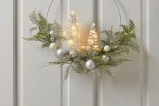 a modern Christmas wreath with greenery, silver baubles and lit up bottlebrush trees is a cool idea for the holidays
