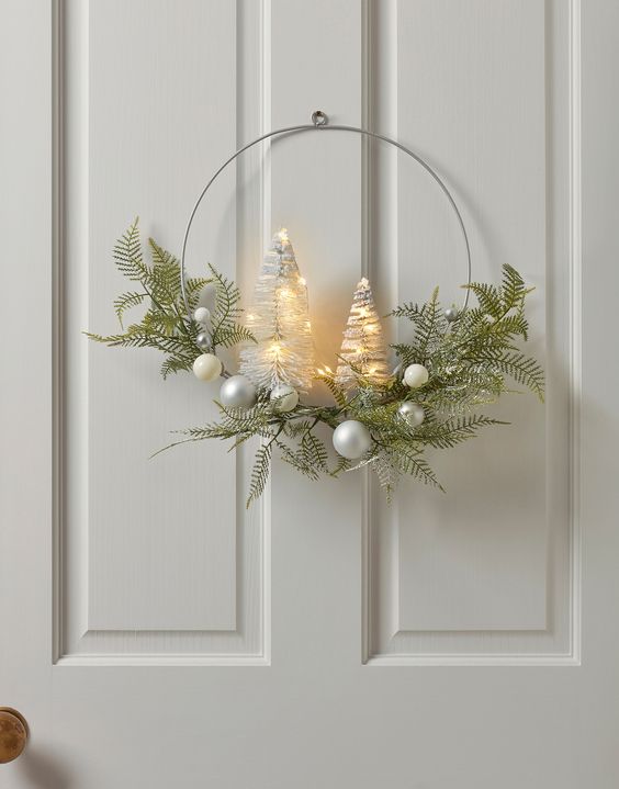 a modern Christmas wreath with greenery, silver baubles and lit up bottlebrush trees is a cool idea for the holidays