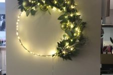 a modern Christmas wreath with lights, greenery and light green ornaments is a lovely decoration to make